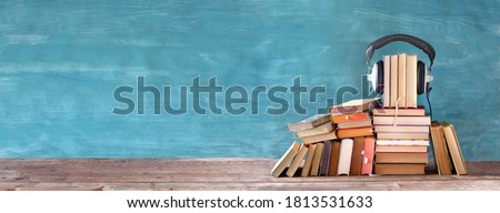 audio book concept with large heap of books and vintage headphones, good copy space Royalty-Free Stock Photo #1813531633