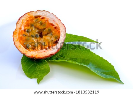 Maracuja cut in half and whole with leaf on white background. Passion fruit with fruit juice and seeds.