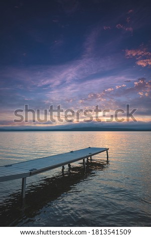 Bright color of the morning fill the sky over a dock on Lake Bernard in Ontario, Canada.