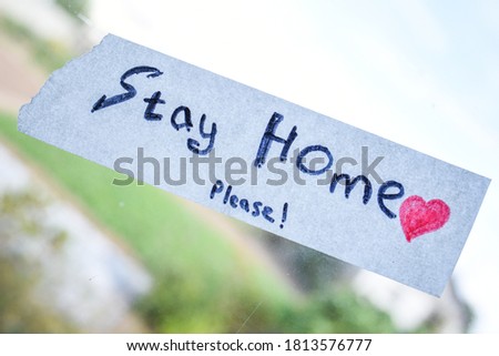 a sign that says stay home and a red heart on the window. a call to stay at home. self-isolation concept