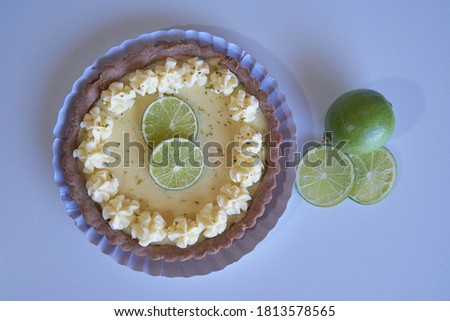 key lime pie. lime pie and whipped cream with sablé dough and garnished with slices and lime zest