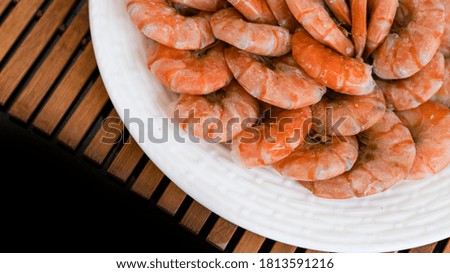 Tiger prawns on a large white plate, blurred background. Seafood.