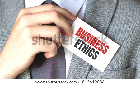 businessman holding a card with text BUSINESS ETHICS