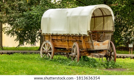 a cowboy wagon without a horse stands on the grass
