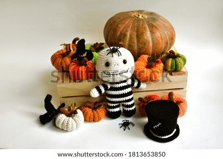Halloween crochet with cute ghost, pumpkins, spiders, witch hat, knitting, handmade, kid, childhood, children, funny, toys in white and vintage wooden crate box background, witch hat, creative