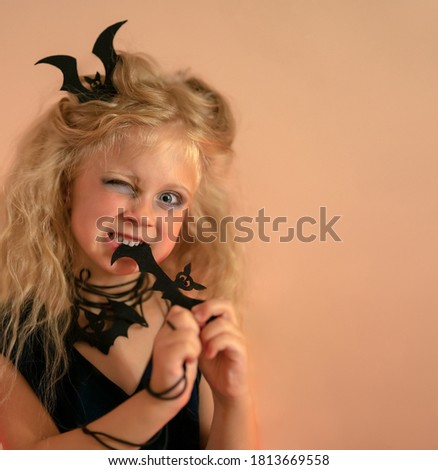 Funny girl in the Halloween costume bites a bat