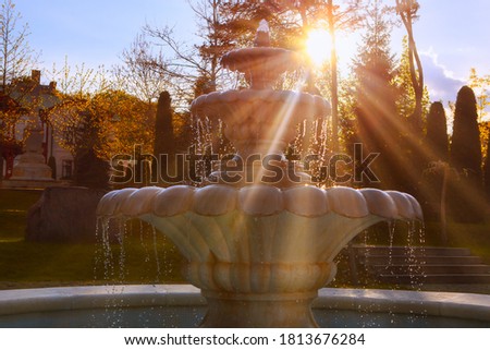 Marble fountain in the sunlight . Tiered Fountain in the Twilight