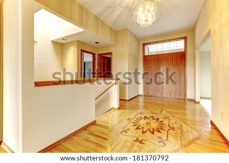 Entrance hallway with hardwood floor and designed picture on it.