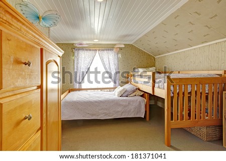 Low vaulted ceiling room with carpet floor and wallpaper wall. Furnished with two beds and dresser