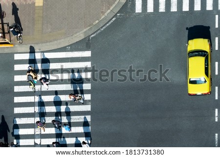 top aerial view of blur men and women walk and bike bicycle across crosswalk in street. Concept normal life of massive people with transportation and car vehicle.