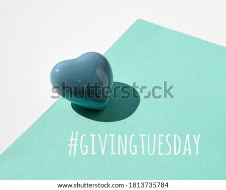 Giving Tuesday, global day of charitable giving. Black Friday of Charity, global charity campaign. Ceramic heart on white and mint green paper background. Text hashtag givingtuesday. Royalty-Free Stock Photo #1813735784