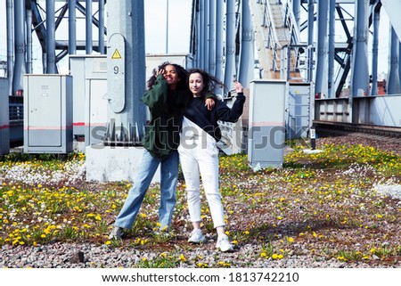 young cute teenage girls together in industrial zone happy smiling having fun, big city lifestyle fashion people