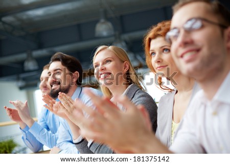 Photo of happy business partners applauding at conference