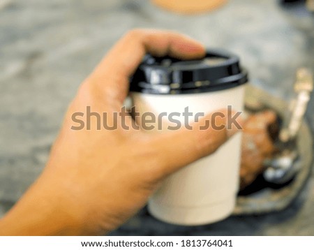 The picture of blur paper coffee cups in men's hands.