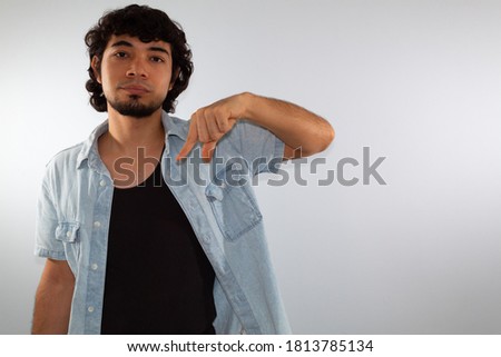 young hispanic deaf man using sign language to communicate, on a white background wearing casual clothes