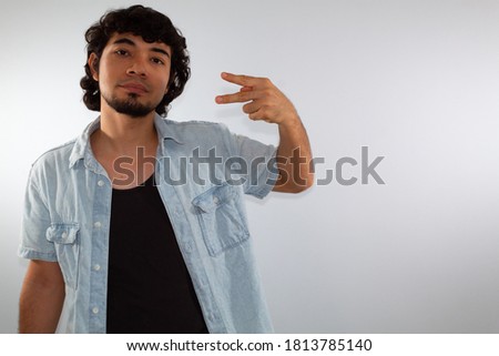 young hispanic deaf man using sign language to communicate, on a white background wearing casual clothes