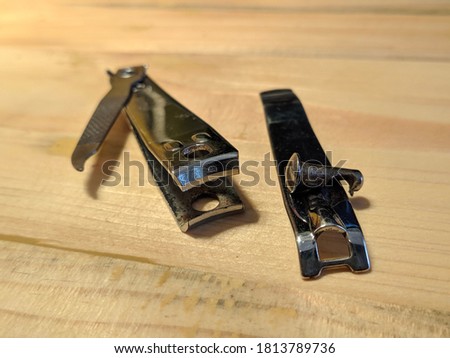 Broken nail clipper on top of the wooden table image
