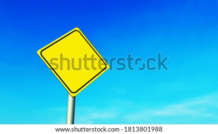 Mockup of a yellow diamond-shaped road sign on a metal pole, against a blue sky