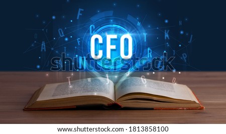CFO inscription coming out from an open book, digital technology concept
