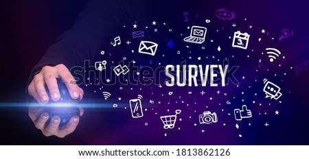 hand holding wireless peripheral with SURVEY inscription, social media concept