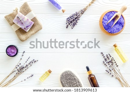 Lavender spa set. Violet bath salt, soap, essence oil on white wooden background