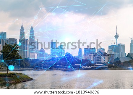Hologram of abstract technology glowing icons, panoramic cityscape of Kuala Lumpur at sunset, Malaysia, Asia. The concept of worlds technological changes. Double exposure.