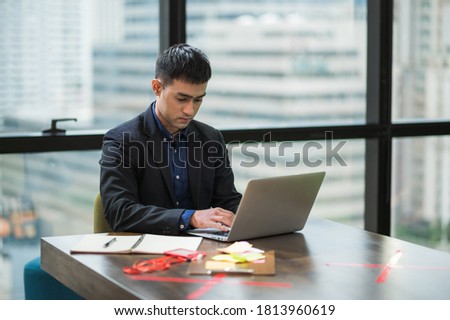 Young asian businessman working with laptop in office.