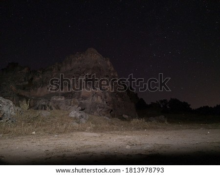 A huge rock and the starry sky appears in the photo.