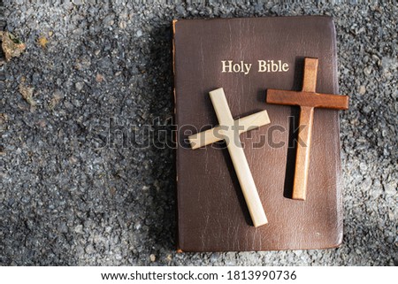 Two cross is placed on top of the Bible.