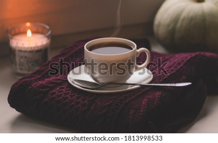 concept of holiday international coffee day presented by composition from a cup of coffee, candle, sweater, pumpkin