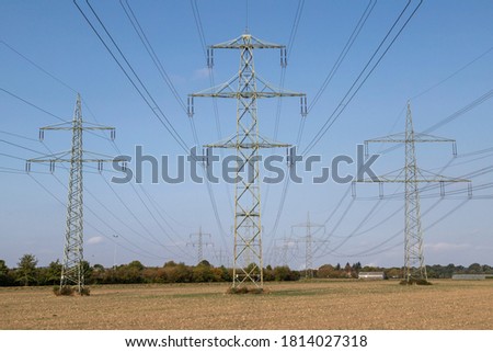 power pylons with power wires with blue sky as background, view from below