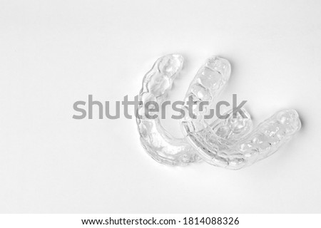 Invisible orthodontic removable braces on a white background with copy space. Aligners for straightening of teeth.  Royalty-Free Stock Photo #1814088326