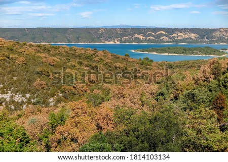 Lake of Sainte-Croix with blue melting water with forest mountains around, commune of Les Salles-sur-Verdon, region of Provence-Alpes-Côte d'Azur, Alpes de Haute Provence, France