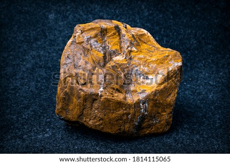 Yellow stone with splashes close-up on a dark background