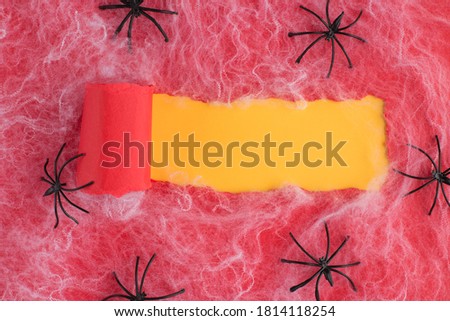 Halloween decor concept. Top above overhead view photo of torn red paper over yellow background with copyspace spiders and spiderweb