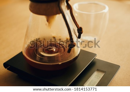 Drip coffee. Coffee drops closeup from filter in glass kettle on scale. Brewing aromatic fresh alternative coffee,  closeup. Barista making filter coffee Royalty-Free Stock Photo #1814153771
