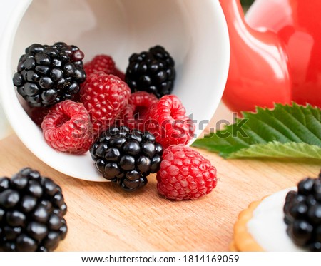 Blackberry and raspberries close up on a wooden background. Colorful delicious concept. A healthy dessert. selective focus