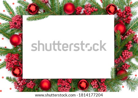 Traditional Christmas background with Christmas decorations in red colors. Christmas frame made of real spruce branches with festive decorations and confetti. Merry christmas design template.