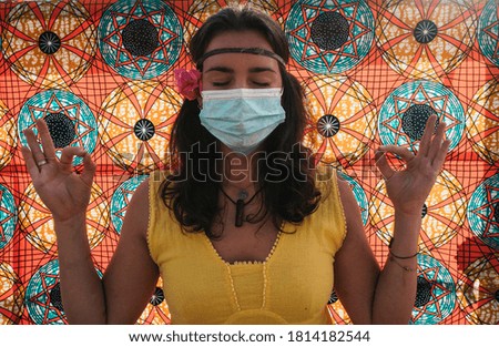 Woman with mask meditating outdoors
