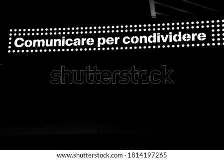 lettering: communicate to share, in white backlit on a black background
