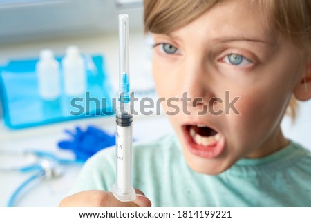 Little girl in doctor's office is afraid of syringe with vaccine. Vaccination for covid-19 coronavirus,flu,dangerous infectious diseases. Injection, clinical trials for human, child. Medicine concept.