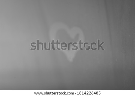Blurred love heart on window, closeup on fogged drops sun shining outdoors background