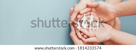 Adult and children hands holding paper family cutout, family home, foster care, homeless charity support concept, family mental health, international day of families Royalty-Free Stock Photo #1814233574