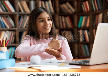 Smiling indian latin deaf disabled child school girl learning online class on laptop communicating with teacher by video conference call using sign language showing hand gesture during virtual lesson. Royalty-Free Stock Photo #1814238713