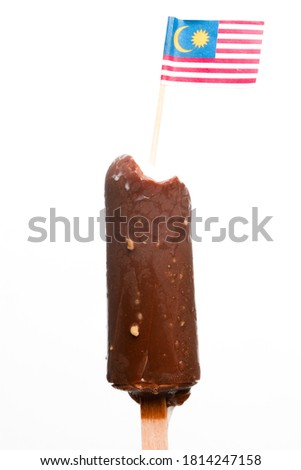 A picture of bitten coco bar with almond and Malaysia flag been put on top at isolated white background.