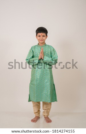 Little boy in tradional dress doing namaste and greeting  Royalty-Free Stock Photo #1814274155