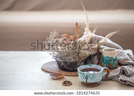 Cozy home still life with a beautiful ceramic Cup of tea on the table. Decorative items in the interior. Royalty-Free Stock Photo #1814274635