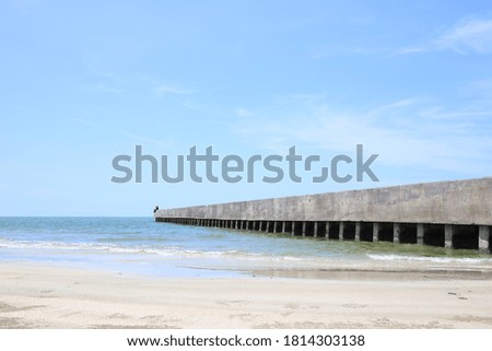 back view of fisherman friends on concrete bridge near tropical beach sitting looking at horizon during beautiful sunny summer bright day on island,sea views. Happy friendship. Leading line to Ocean