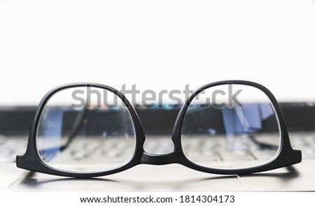 close up eyeglasses on a laptop computer with display screen background.
