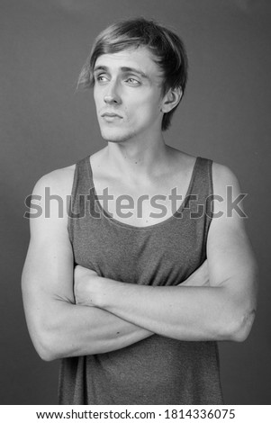 Young handsome man ready for gym against gray background